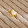 Detalle macro de un anillo de corazón dorado con incrustación blanco perla y banda - Estilo Corazón Hueco Blanco Perlado (227) / Dorado