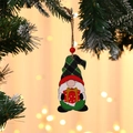 Detail of wooden gnome Christmas ornament with gift box hanging on a tree branch - Gift Bag Style