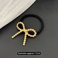 Minimalistisches elastisches Haargummi mit goldener Metallperlen Schleife für Damen - Gedrehte Schleife Gold
