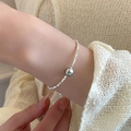 Close-up of a silver beaded bracelet with a grey pearl on a knit sleeve background - Crushed Silver Artificial Pearl Style (MY36410)