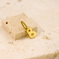Minimalist stainless steel gold-finished letter B pendant on a textured stone surface - Letter-B / Gold