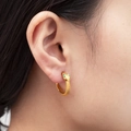 Gold-plated snake earrings with green gem eyes worn by a woman, vintage style - Gold