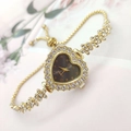 Close-up of heart-shaped gold quartz watch with rhinestone flower chain and bolo clasp - Gold Case Black