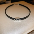 Détail d'un choker en cuir noir doté d'une boucle en métal argenté poli au motif CD - Collier Ras du Cou en Cuir Noir avec Lettre