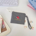Close-up of black and white checkered coin pouch with mushroom embroidery and lanyard - Mushroom