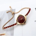 Detail of luxury gold quartz watch with red stones and a delicate diamond-set dial - Red