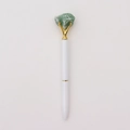 Detail van witte metalen balpen met ruwe groene kristalsteen en gouden klauwzetting - Aventurijn jade