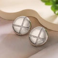 Dettaglio macro di orecchini geometrici in argento con zirconi su un panno beige ruvido - Rotondo / Argento
