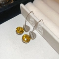 Detail view of silver drop earrings featuring faceted yellow crystals on light fabric - Yellow Stone Silver Hook