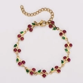 Close-up of bohemian gold cherry bracelet with red crystal charms and green enamel leaves - Deep purple