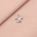 Macro shot of silver stainless steel sea turtle pendant with circular textures on pink fabric - 8# Sea Turtle Style