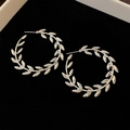 Detailed view of silver leaf-shaped hoop earrings on a black velvet jewelry box - 25# Silver Post Style (25#)