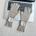 Close-up of camel knitted wool gloves with letter patch on a laptop keyboard - One Size / Khaki