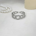 Makroaufnahme des silbernen Gliederkettenrings mit Textur auf weißem Stoffhintergrund - Edelstahl Hohlkette Twist Armband / Silber