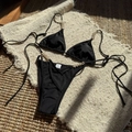 Detalle de bikini negro con perlas blancas y etiqueta de lavado con indicación de talla S - S / Negro