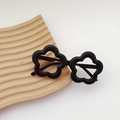 Stylish black flower-shaped kids' sunglasses with glossy finish on a wooden tray - Single Frame / Black