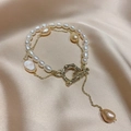 Gold layer chain bracelet with Baroque pearl charm and white pearls on silk background - Freshwater Pearl Double Layer Style