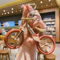 Detail of balance bike keychain in cream and orange with metal lobster clasp - Burgundy