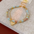 Dettaglio bracciale a doppio strato con perline blu chiaro e ciondolo a forma di cuore d'oro - Bracciale a Doppia Fila con Perline Colorate (Ciondolo a Cuore)