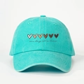 Close-up of heart embroidery and 'one day at a time' text on mint green baseball cap - Adjustable / Lake Blue