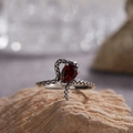 Macro shot of vintage S925 silver snake ring with teardrop garnet on beige rock - Natural Garnet Snake Ring LR395