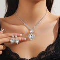 Detailed view of silver heart-shaped rhinestone necklace and earrings set on a model - Silver 206-Large Heart Full Rhinestone