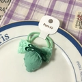 Green fabric strawberry hair scrunchie with plaid bow and lace detail on a ceramic plate - Green System