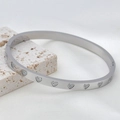Silver stainless steel bangle with sparkling zircon heart patterns on a stone base - Heart / Steel