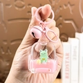 Roze cartoon beer sleutelhanger met transparante capsule en groene kikkerpop - Rugzak Kikker-Roze