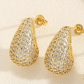 Macro shot of gold teardrop earrings featuring a pavé setting of brilliant white zircons - White Zirconia