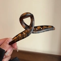 Detail showing the glossy tortoiseshell pattern on a large acetate hair claw clip - Large Brown Tortoiseshell Cross Claw Clip