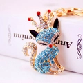 Exquisite gold fox keychain with blue rhinestones and crown on a book background - Blue
