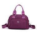 Bolso de mano de nailon morado con herrajes plateados y correa desmontable en luz de estudio - Morado