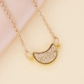 Collar de luna dorada con incrustaciones brillantes sobre fondo de elegante seda beige - Champán