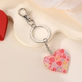 Detalle de llavero de corazón acrílico con motivos coloridos y mensajes de amor impresos - Corazón con Texto XOXO Rosa