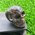 5cm hand-carved natural semi-precious stone skull with polished red-brown texture - Sesame Stone