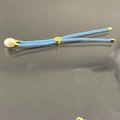 Adjustable light blue woven bracelet with white pearl and gold accents on grey surface - Light Blue
