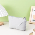 Grey dumpling-shaped makeup bag with pleated texture and silver zipper in home setting - Pleated Texture Style / Gray Yuanbao Bag