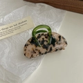 Detail of tortoise shell claw clip with green handle on a white textured background - Light Leopard Print Handle Claw