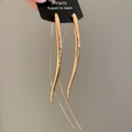 Macro shot of polished gold-plated teardrop earrings with a sleek mirror-like finish - Gold
