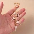 Golden heart keychain with pink enamel charms and letter G pendant held by hand - Pink Heart