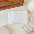 Close-up of white cotton makeup bag with vertical lace embroidery and smooth zipper detail - White
