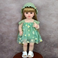 55cm reborn doll in green daisy dress and sun hat standing on a wooden stool - Green Daisy Dress Blonde Hair / Full Set (With Clothes)