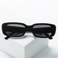 Vintage black rectangle sunglasses with 90s retro narrow frame on a white minimalist block - Rose Red Frame Rose Red Lenses