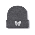Close-up of white butterfly embroidery on a grey ribbed knit beanie with folded cuff - One Size / Dark Gray