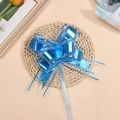 Close-up of blue matte metallic snow yarn ribbon bow with silver edge on woven mat - Light Blue