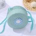 Close-up of mint blue woven straw shoulder bag with daisy embroidery for girls - Diameter 12cm / Small Round Bag Blue Daisy / Blue