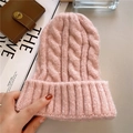 Detailansicht der rosa Zopfmuster-Strickmütze mit Magazin und Parfüm im Hintergrund - M(56-58cm) / Rosa