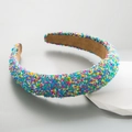 Fashionable wide headband with colorful sprinkle design on white geometric display stand - Blue