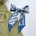 Navy and white C-patterned satin hair ribbon styled on an olive green blazer lapel - Blue Letter C